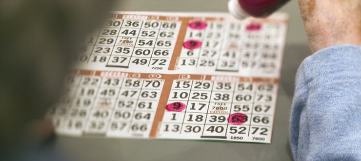 Woman using bingo dabber on bingo card