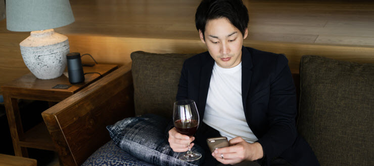 Man holding glass of wine in a hotel lobby